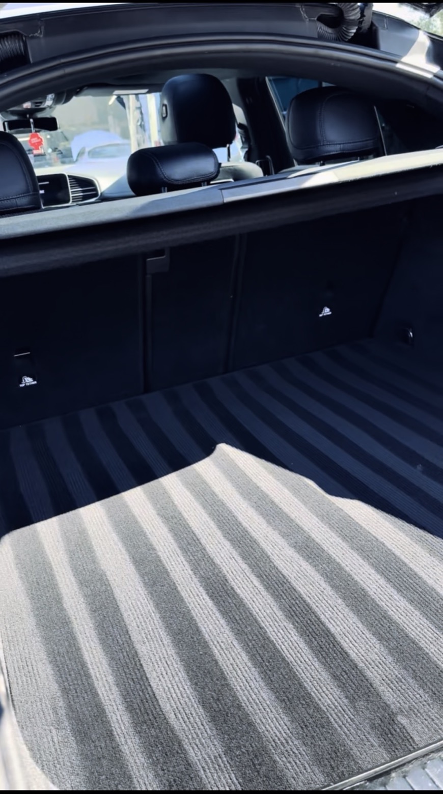 Le même coffre après nettoyage : moquette aspirée et brossée, tapis remis en place