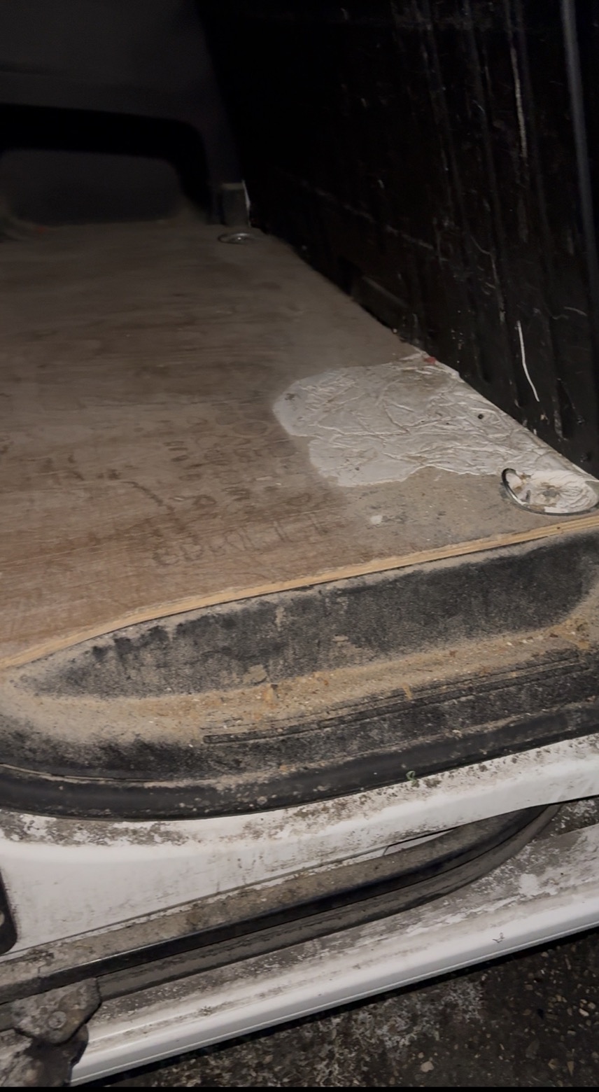 Utilitaire avant nettoyage : plancher en bois et seuil recouverts de sable et de saletés